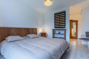 a bedroom with a bed and a chair and a window at Le Francvillois in Villefranche-Sur-Cher