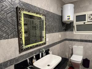 Un baño con lavabo, espejo e inodoro. en New Cairo Hotel Apartment, en Madīnat ash Shurūq 10 fotos más