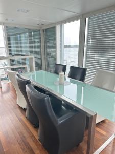 a conference room with a glass table and chairs at schwimmendes Ferienhaus Silent in Elsterheide
