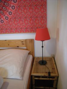 a bedroom with a bed with a red lamp on a night stand at Rhön-Antik in Dipperz