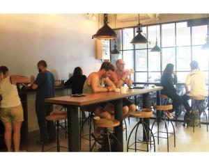 a group of people sitting at a table in a restaurant at My Studio Hotel City Center in Surabaya