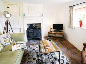 a living room with a couch and a table at Hidden Cottage by The Suffolk Cottage Collection in Aldeburgh
