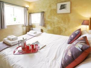 a bedroom with a white bed with a tray on it at Hidden Cottage by The Suffolk Cottage Collection in Aldeburgh
