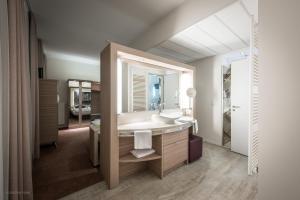 ein Badezimmer mit Waschbecken und Spiegel in der Unterkunft Arkadenhaus - Hotel Freiherr von Schwarzenberg in Papenburg