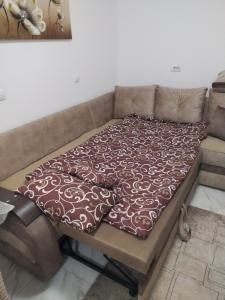 eine Couch mit einer Decke darüber in der Unterkunft Nina centar in Sombor