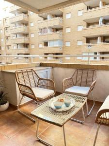 a patio with two chairs and a table on a balcony at Paraiso en la playa con terraza in El Borseral
