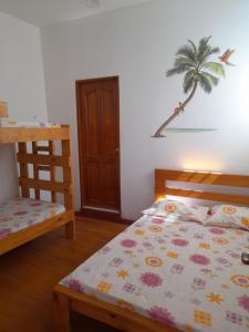 a bedroom with a bed and a palm tree on the wall at Cabaña frente al mar de San Antero in San Antero