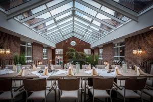 ein Esszimmer mit Tischen und Stühlen und einer Glasdecke in der Unterkunft Arkadenhaus - Hotel Freiherr von Schwarzenberg in Papenburg