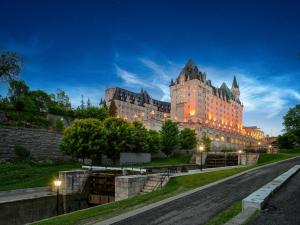 a large building at night with lights on at Fairmont Chateau Laurier in Ottawa