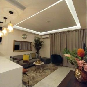 イロイロにあるDeluxe Condo 2 Bedroom, 7th Floor Room BC in One Madison Tower 3, Megaworld Boulevard, Mandurriao Iloilo City, Philippinesのソファとテーブルのあるリビングルーム