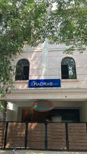 a white building with a blue sign on it at Madras Inn - Alwarpet in Chennai