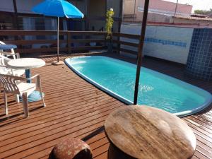 a swimming pool on a deck with a table and an umbrella at Casa Bela Marta in Fundão