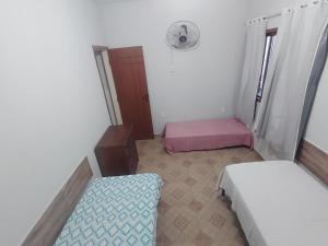 a small room with two beds and a fan at Casa Bela Marta in Fundão +12 photos