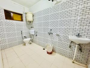 un bagno con lavandino e WC di Silver Land with mountain view - A River side property a Manāli