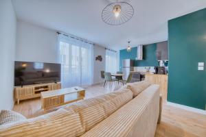 a living room with a couch and a kitchen at Le Boulingrin in Reims