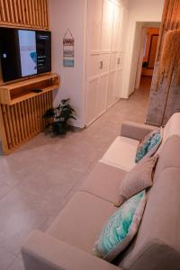 a living room with a couch and a tv at Tropical Suite 22 B in Santa Maria