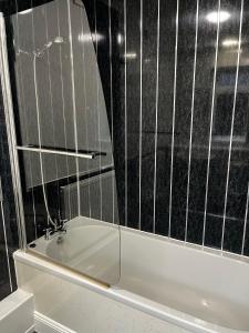 ストックトン・オン・ティーズにあるLevy Nook House 1 bed apartment 5 minute walk to Stockton town centre & Free Parkingのバスタブと鏡のあるバスルーム