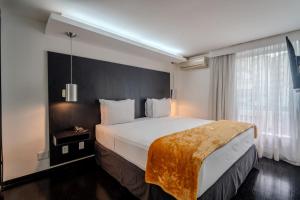 a bedroom with a large bed and a window at 155 Hotel in Sao Paulo