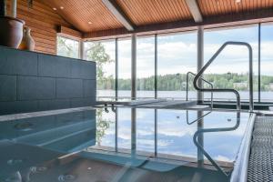 a pool in a house with a view of the water at Hotel Kumpeli Spa in Heinola