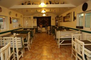 a restaurant with tables and chairs in a room at Pensiunea Empire in Baile Unu Mai