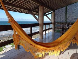 - un hamac sur une terrasse couverte donnant sur l'océan dans l'établissement Casa Jangada - Incrível vista mar com Piscina e a melhor localização na Beira Mar da Taíba, à Taíba