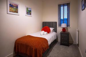 a bedroom with a bed with a red pillow on it at Spacious 2 Bedroom Apartment in Crawley in Crawley