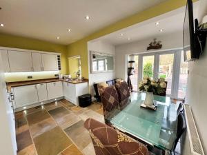 a kitchen and living room with a glass table and chairs at 3 Bedrooms - 2 Bath Rooms - Dog Friendly - Parking in Berwick-Upon-Tweed