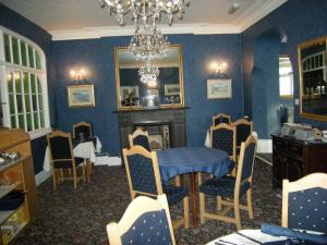 a dining room with blue walls and a table and chairs at Headlands Hotel in Llandudno