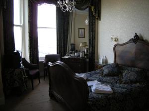 a bedroom with a bed and a desk and a window at Headlands Hotel in Llandudno