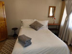 Cave View self catering cottages في Beckedan: سرير مع ملاءات ووسائد بيضاء في غرفة النوم +41 صورة