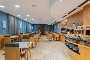 a restaurant with blue walls and wooden tables and chairs at Hotel del Mar in Barcelona