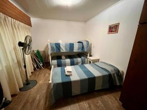 una camera con 3 letti e un ventilatore di Quinta a metros del Parque Municipal y La Antigua Pulpería a Mercedes Altre 13 foto