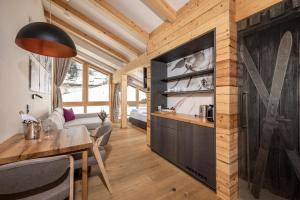 kuchnia i salon z drewnianą ścianą w obiekcie Austria Alpinhotel Ski IN Ski OUT an der Edelweissbahn w mieście Obertauern