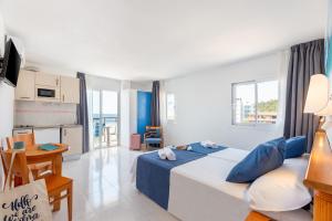 a bedroom with a large bed and a kitchen at Vibra Calima Apartamentos - Adults only in San Antonio +15 photos