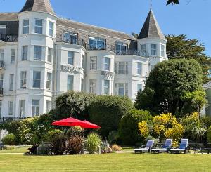 a large white building with a red umbrella in front of it at Royal Bath Hotel Bournemouth in Bournemouth