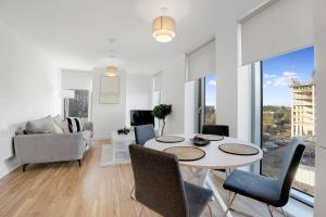 a living room with a table and chairs at Luxury 2BR in Media City in Manchester