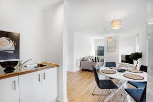 a kitchen and a living room with a table and chairs at Luxury 2BR in Media City in Manchester