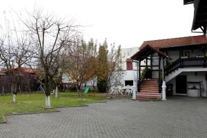 uma casa com um pátio com mesas e cadeiras em Pensiunea Doina & Jenő em Târgu-Mureş
