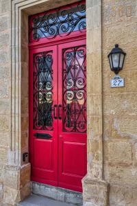 a red door on the side of a building at Maltese Maisonette in Historic Isla with Sea Views by 360 Estates in Senglea
