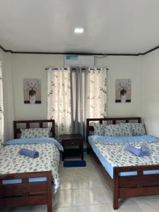 two beds in a room with two beds sidx sidx sidx at Princesa Michaella Hostel in Itaytay