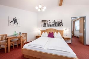 sypialnia z łóżkiem, biurkiem i stołem w obiekcie Austria Alpinhotel Ski IN Ski OUT an der Edelweissbahn w mieście Obertauern
