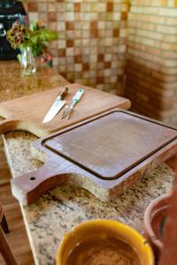 a wooden cutting board with a knife and fork on a counter at Praia de Juquehy a 5 minutos | Charme Rústico in São Sebastião