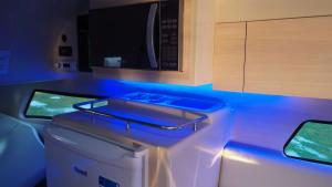 a kitchen with blue lights and a microwave at Praia de Juquehy a 5 minutos | Charme Rústico in São Sebastião