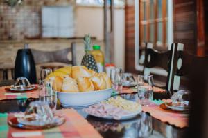 a table with a bowl of hot dogs and bananas on it at Praia de Juquehy a 5 minutos | Charme Rústico in São Sebastião +39 photos