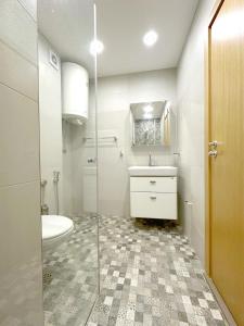 a bathroom with a toilet and a sink and a mirror at Old City Views - Luxury 2BDR Apt & Free Parking in Sofia