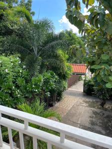 una valla blanca frente a un jardín con árboles en ชรัส รีสอร์ท เกาะล้าน, en Ko Sak 7 fotos más
