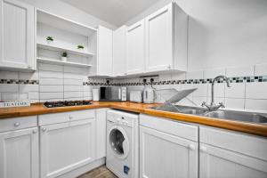 een witte keuken met een spoelbak en een vaatwasser bij Stylish Three Bedroom House - Accommodates 7 - Parking Available - Garden - Recently Renovated - Top Rated - 162S in Birmingham
