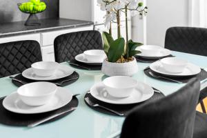 een blauwe tafel met zwarte stoelen en witte kopjes en schotels bij Stylish Three Bedroom House - Accommodates 7 - Parking Available - Garden - Recently Renovated - Top Rated - 162S in Birmingham