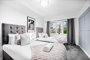 een slaapkamer met twee bedden en een raam bij Stylish Three Bedroom House - Accommodates 7 - Parking Available - Garden - Recently Renovated - Top Rated - 162S in Birmingham