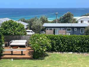 a backyard with a bench and a table and a house at The G Shack at Rennies Beach in Ulladulla +16 photos